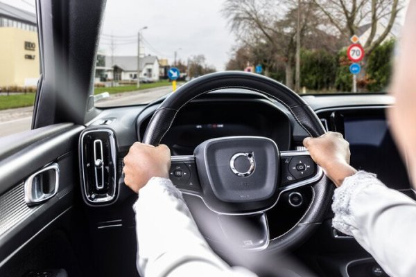 chauffeur in auto met handen aan het stuur